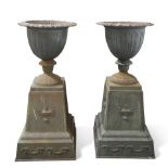 A PAIR OF CAST IRON URNS ON STANDS