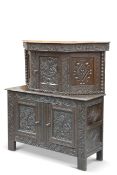 A CARVED OAK CUPBOARD