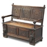 A VICTORIAN CARVED OAK SETTLE