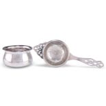 AN ART DECO SILVER TEA STRAINER ON STAND