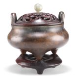 A CHINESE PATINATED BRONZE TRIPOD CENSER