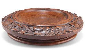 A 19TH CENTURY CARVED WALNUT WINE COASTER