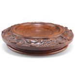 A 19TH CENTURY CARVED WALNUT WINE COASTER