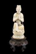 A CHINESE CARVED IVORY FIGURE OF AN ACOLYTE