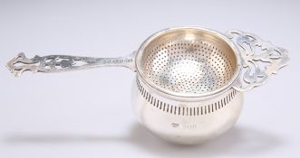 A GEORGE V SILVER TEA STRAINER ON STAND