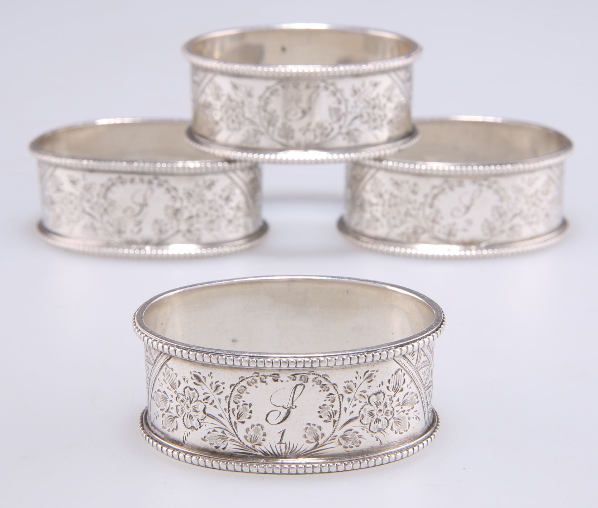 A SET OF FOUR VICTORIAN SILVER NAPKIN RINGS