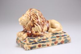 A 19TH CENTURY POTTERY MODEL OF A RECUMBENT LION