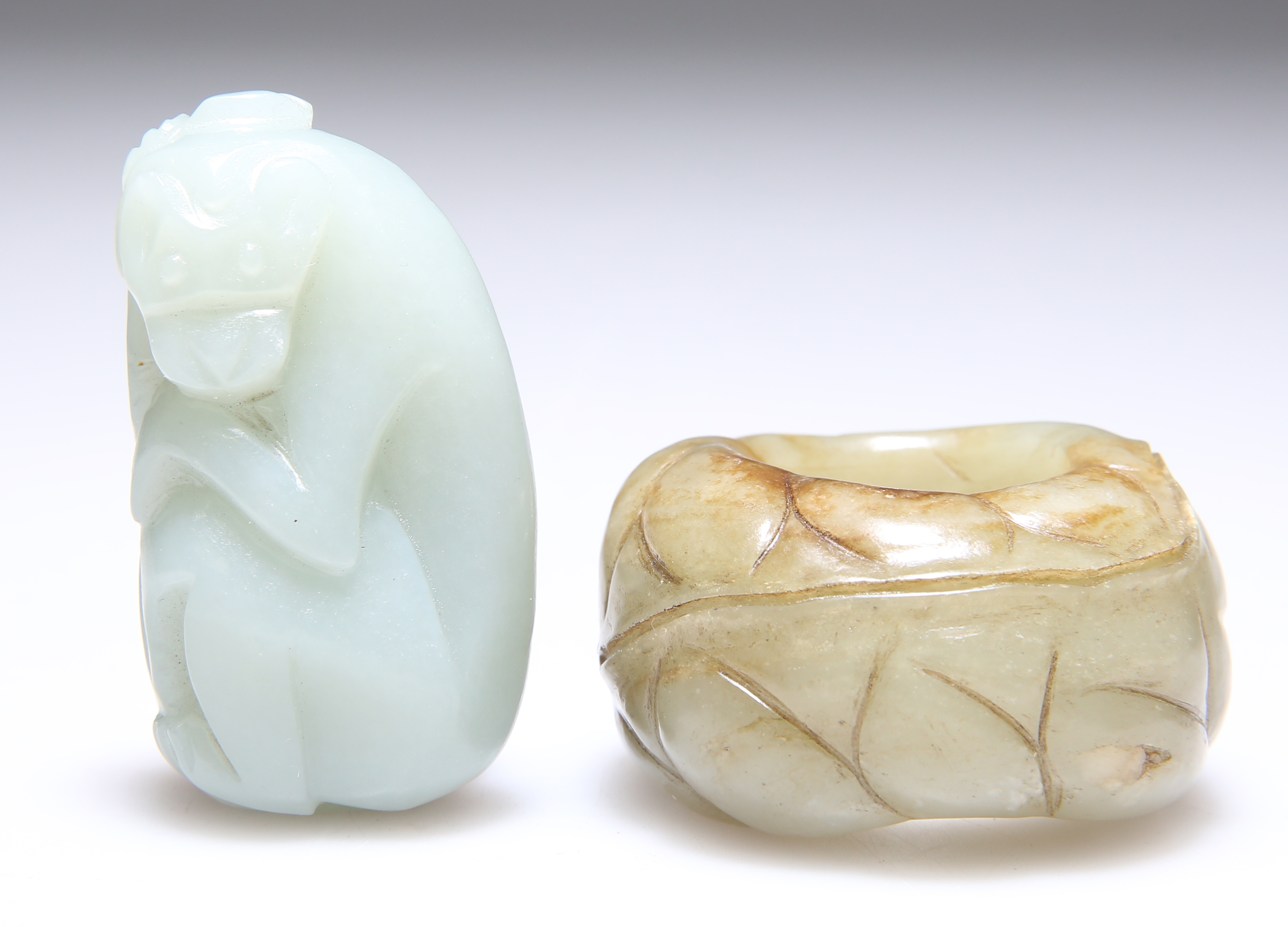 A JADE THUMB RING AND A CARVING