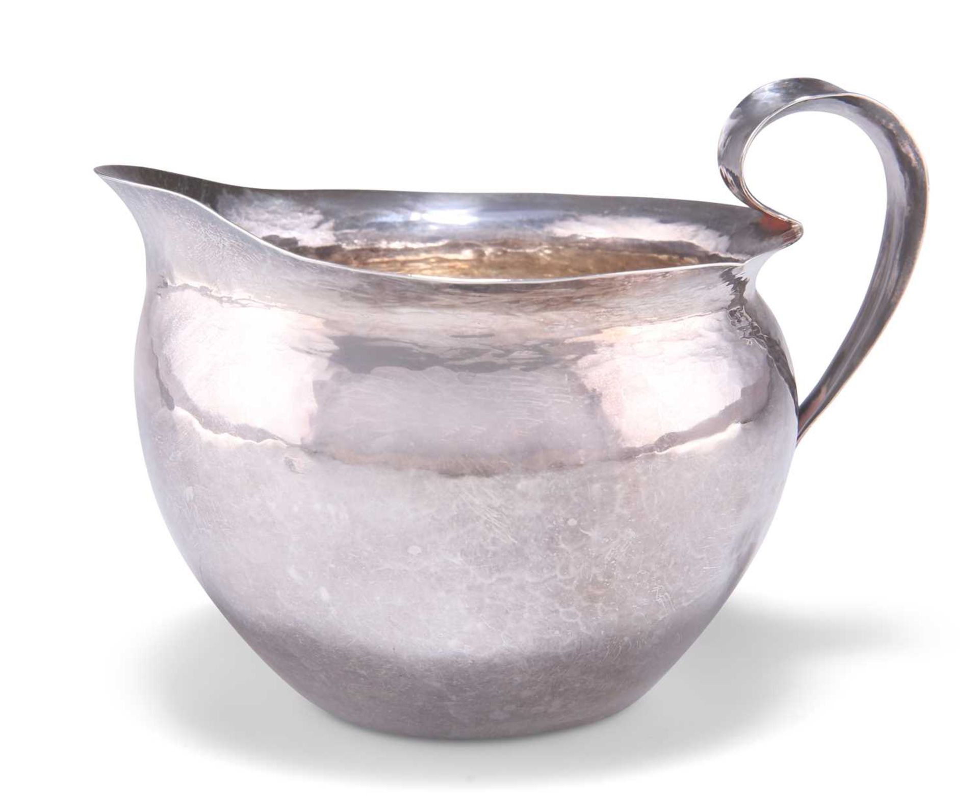 AN ARTS AND CRAFTS SPOT-HAMMERED SILVER JUG