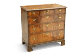 AN OAK AND WALNUT CHEST OF DRAWERS