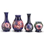 FOUR WALTER MOORCROFT ANEMONE PATTERN TUBE LINED POTTERY VASES