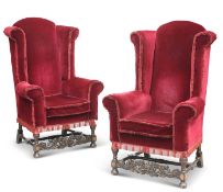 A PAIR OF CAROLEAN STYLE OAK AND UPHOLSTERED HIGH-BACK WING CHAIRS, CIRCA 1920S