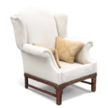 A CHIPPENDALE STYLE MAHOGANY AND UPHOLSTERED WING-BACK CHAIR