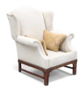 A CHIPPENDALE STYLE MAHOGANY AND UPHOLSTERED WING-BACK CHAIR