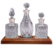 A SET OF THREE SILVER-MOUNTED CUT-GLASS DECANTERS