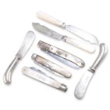 A GROUP OF FOUR SILVER BUTTER KNIVES, AND THREE SILVER AND MOTHER-OF-PEARL FOLDING FRUIT KNIVES