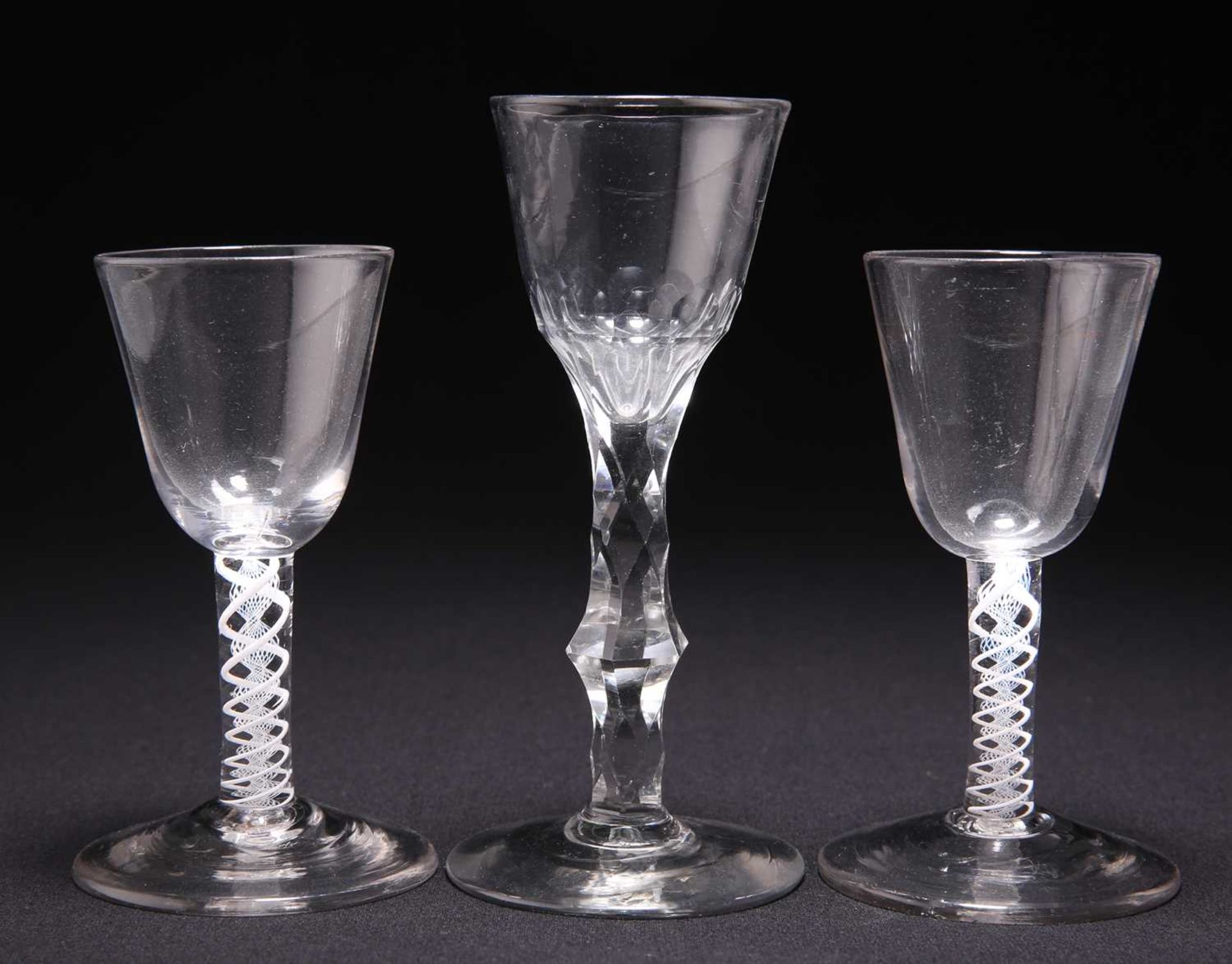 TWO 18TH CENTURY OPAQUE TWIST SMALL WINE GLASSES AND A FACETED STEM WINE GLASS