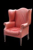 AN EDWARDIAN STAINED BEECH AND LEATHER UPHOLSTERED WING-BACK ARMCHAIR