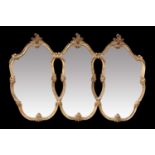 A PERIOD STYLE GILT-COMPOSITION TRIPARTITE MIRROR