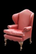 AN EARLY 20TH CENTURY LEATHER-UPHOLSTERED OAK WING-BACK ARMCHAIR