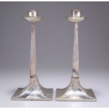 A PAIR OF ARTS AND CRAFTS SILVER CANDLESTICKS