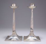 A PAIR OF ARTS AND CRAFTS SILVER CANDLESTICKS
