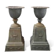 A PAIR OF CAST IRON URNS ON STANDS