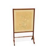 AN EDWARDIAN MAHOGANY AND NEEDLEWORK FIRESCREEN