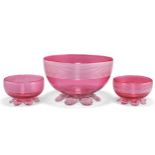 A LARGE CRANBERRY GLASS BOWL AND A SMALL PAIR OF BOWLS