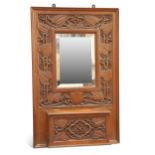 GIGGLESWICK SCHOOL, AN ARTS AND CRAFTS CARVED OAK HALL MIRROR CIRCA 1905