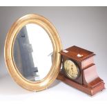 A FAUX ROSEWOOD CASED MANTEL CLOCK AND AN OVAL WALL MIRROR