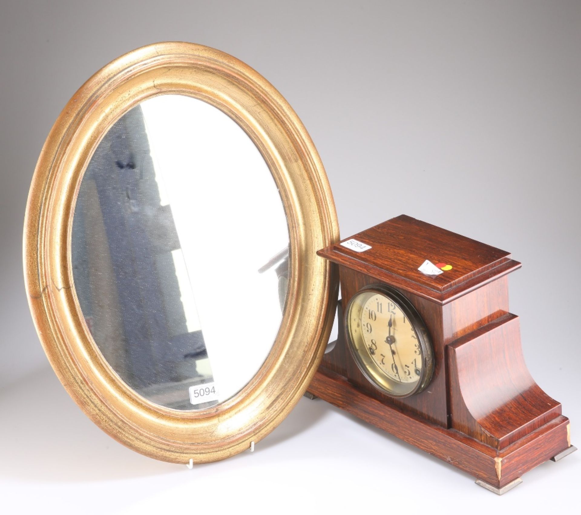 A FAUX ROSEWOOD CASED MANTEL CLOCK AND AN OVAL WALL MIRROR