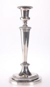 A SILVER PLATED CANDLESTICK OF TAPERING FORM WITH CIRCULAR BASE