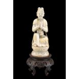 A CHINESE CARVED IVORY FIGURE OF AN ACOLYTE, QING DYNASTY, 17TH-18TH CENTURY, carved sitting in