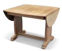 AN ARTS AND CRAFTS OAK DROPLEAF SUPPER TABLE, the boat-shaped top with drop-ends, raised on a