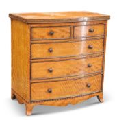 A FINE EARLY 19TH CENTURY SATINWOOD BOW-FRONTED MINIATURE CHEST OF DRAWERS, the top with inlaid edge