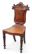 A MID-19TH CENTURY MAHOGANY HALL CHAIR, the U-shaped back carved with a horse head crest. Height