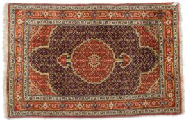 AN AFGHAN HERAT RUG, hand-knotted, the dark blue field with red medallion and corners, the whole