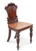 A MID-19TH CENTURY MAHOGANY HALL CHAIR, with C-scroll carved cartouche-shaped back. Height of back