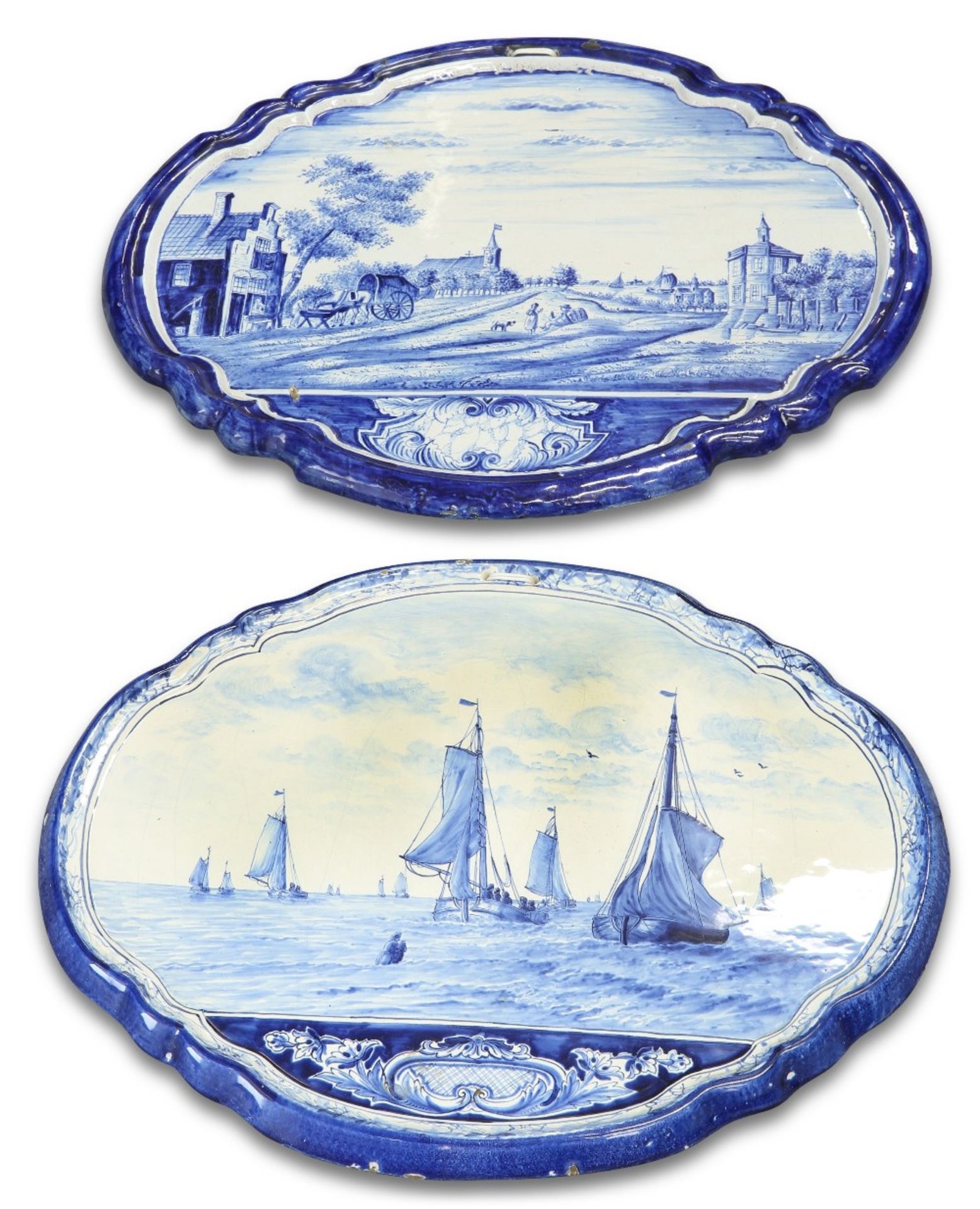 TWO SIMILAR DUTCH DELFT BLUE AND WHITE SHAPED OVAL WALL PLAQUES, PROBABLY MAKKUM, 19TH CENTURY,