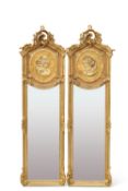 A PAIR OF PERIOD-STYLE GILT-COMPOSITION MIRRORS, each moulded with the head of a maiden below a