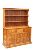 A CRYER CRAFT ELM DRESSER AND RACK,ÿthe rack with two fixed shelves, the base with three drawers