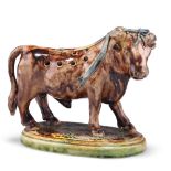 A 19TH CENTURY MAJOLICA NOVELTY TOOTHPICK HOLDER, in the form of a prize bull, on a naturalistic