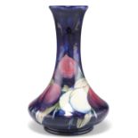 A WILLIAM MOORCROFT POTTERY VASE,ÿsquat baluster form with a long flared neck, 'Plum Wisteria'