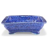 A CHINESE BLUE-GLAZED DISH, rectangular with inverted corners, the thickly potted body with