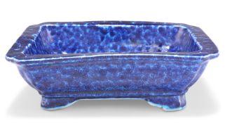 A CHINESE BLUE-GLAZED DISH, rectangular with inverted corners, the thickly potted body with