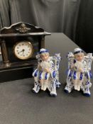 Two pressed porcelain figures of boys, and a black slate mantel clock