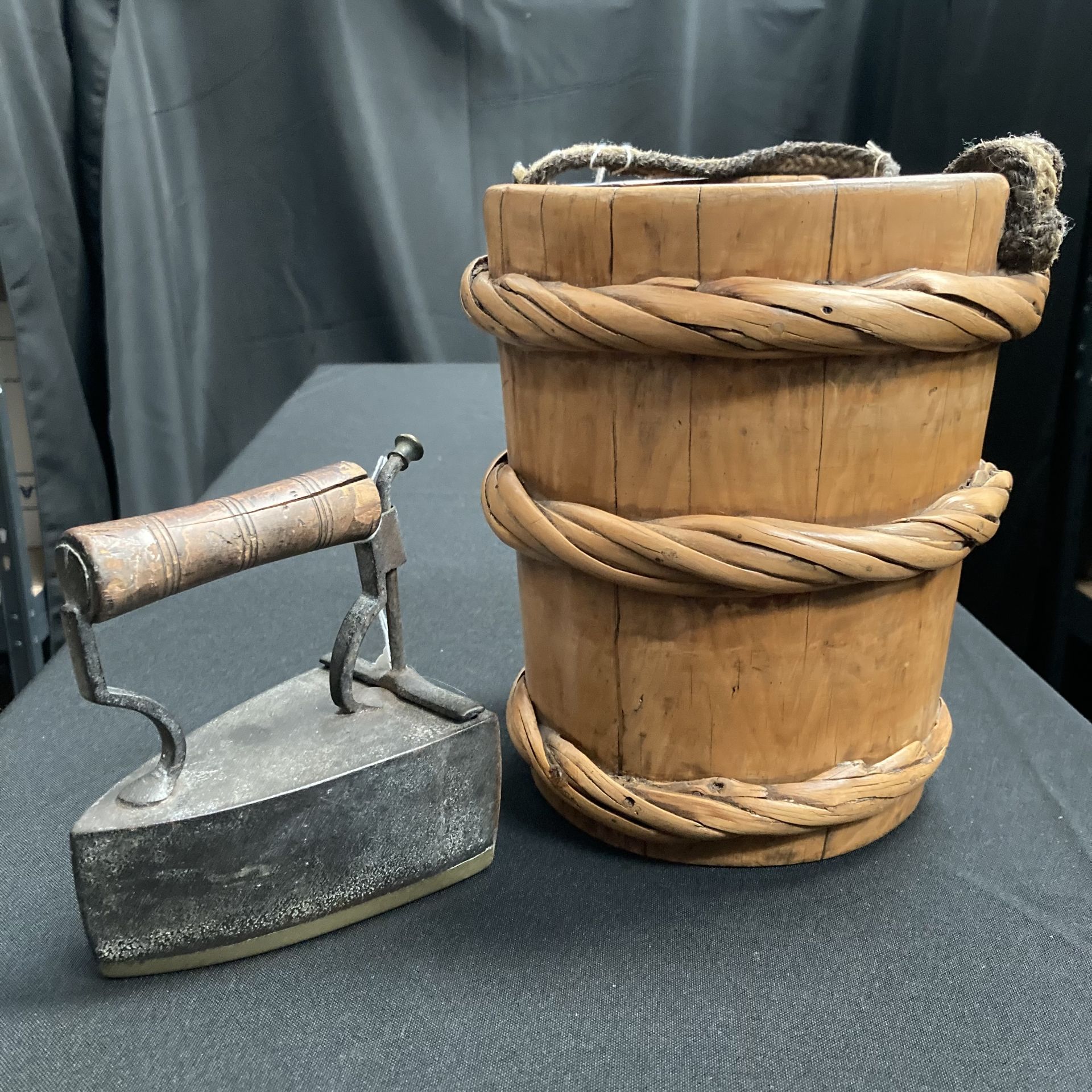 A cane-bound wooden milk pail; and a coal-filled iron