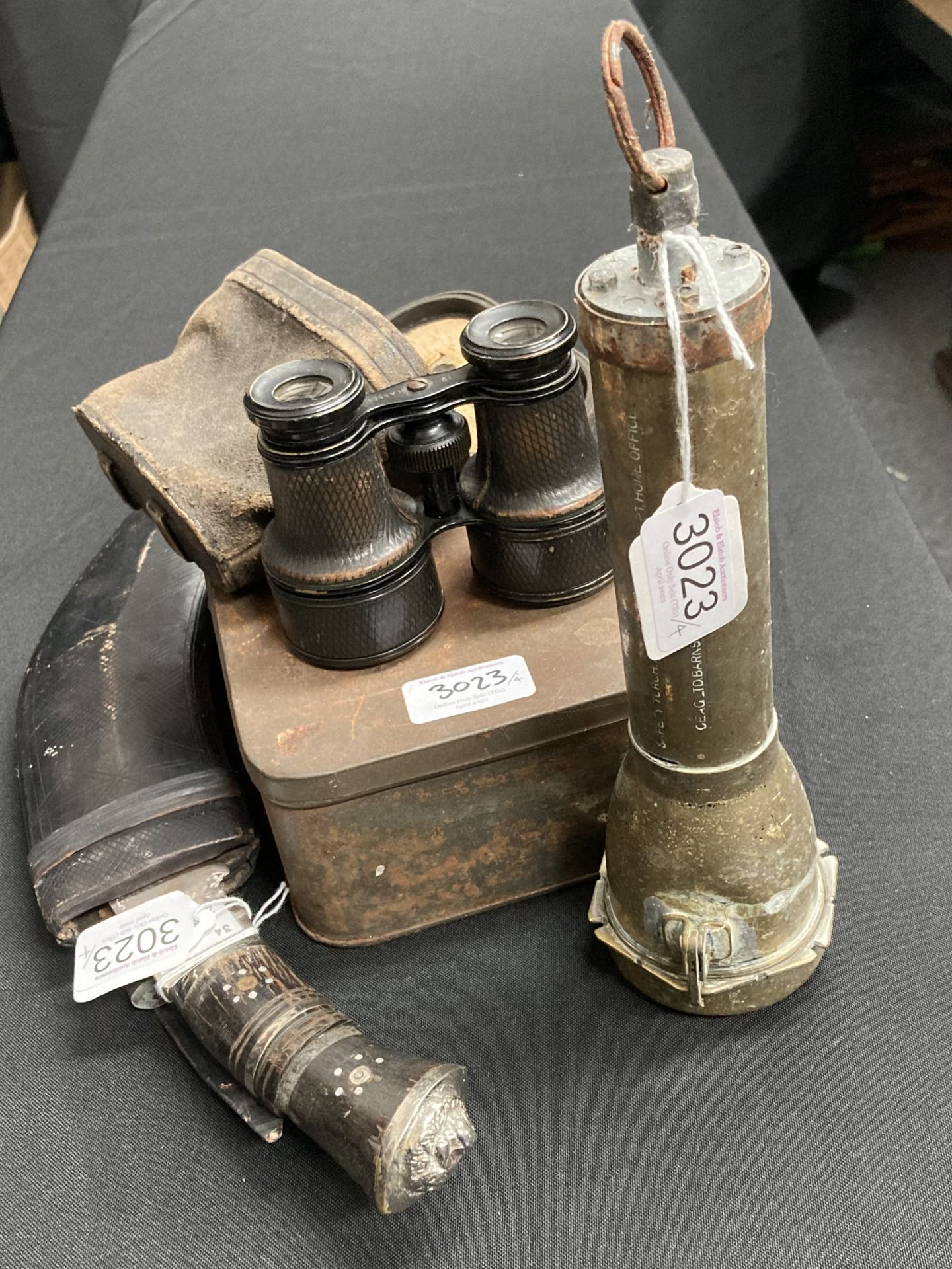 A kukri, binoculars, brass torch and tin of clays pipes