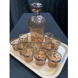 A silver and ochre coloured glass drinks set